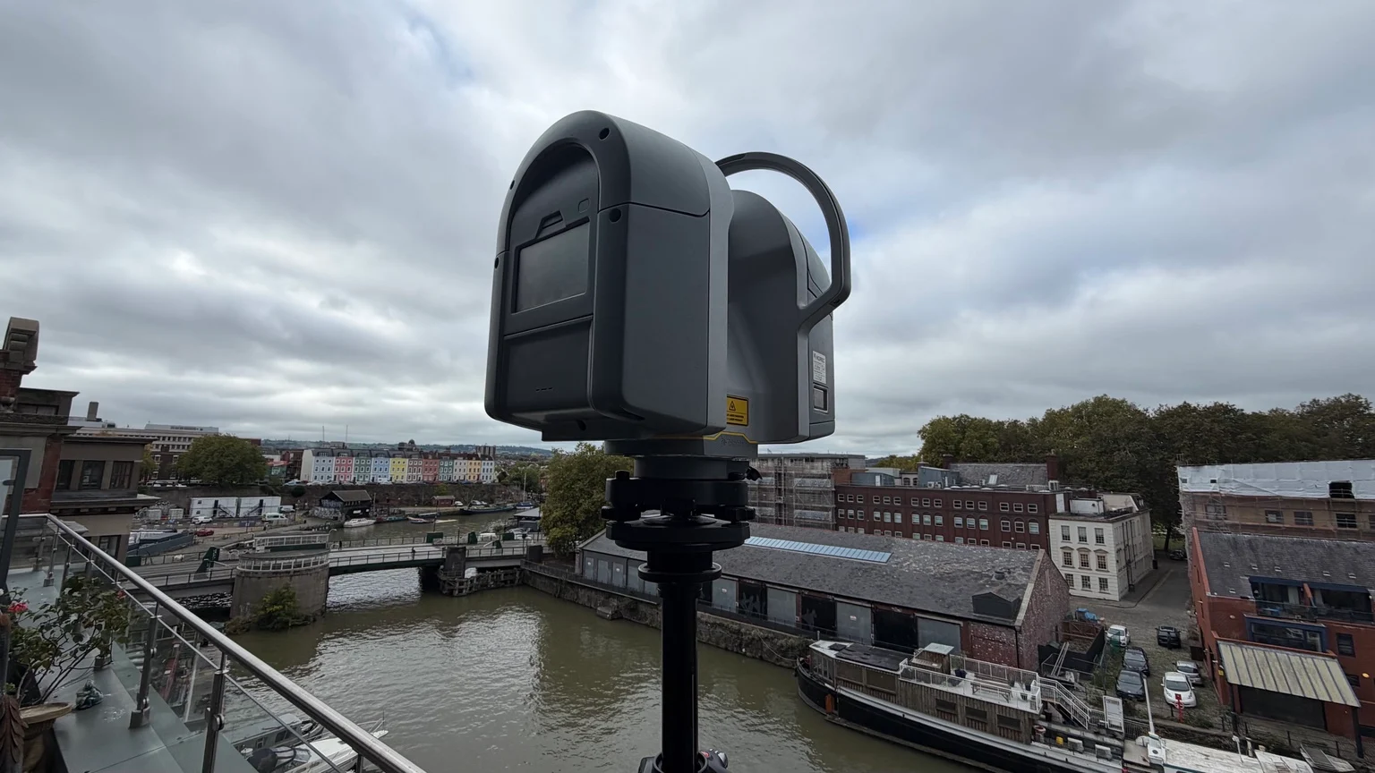 Close view of a tripod-mounted laser scanner on a balcony above the canal in Bristol.