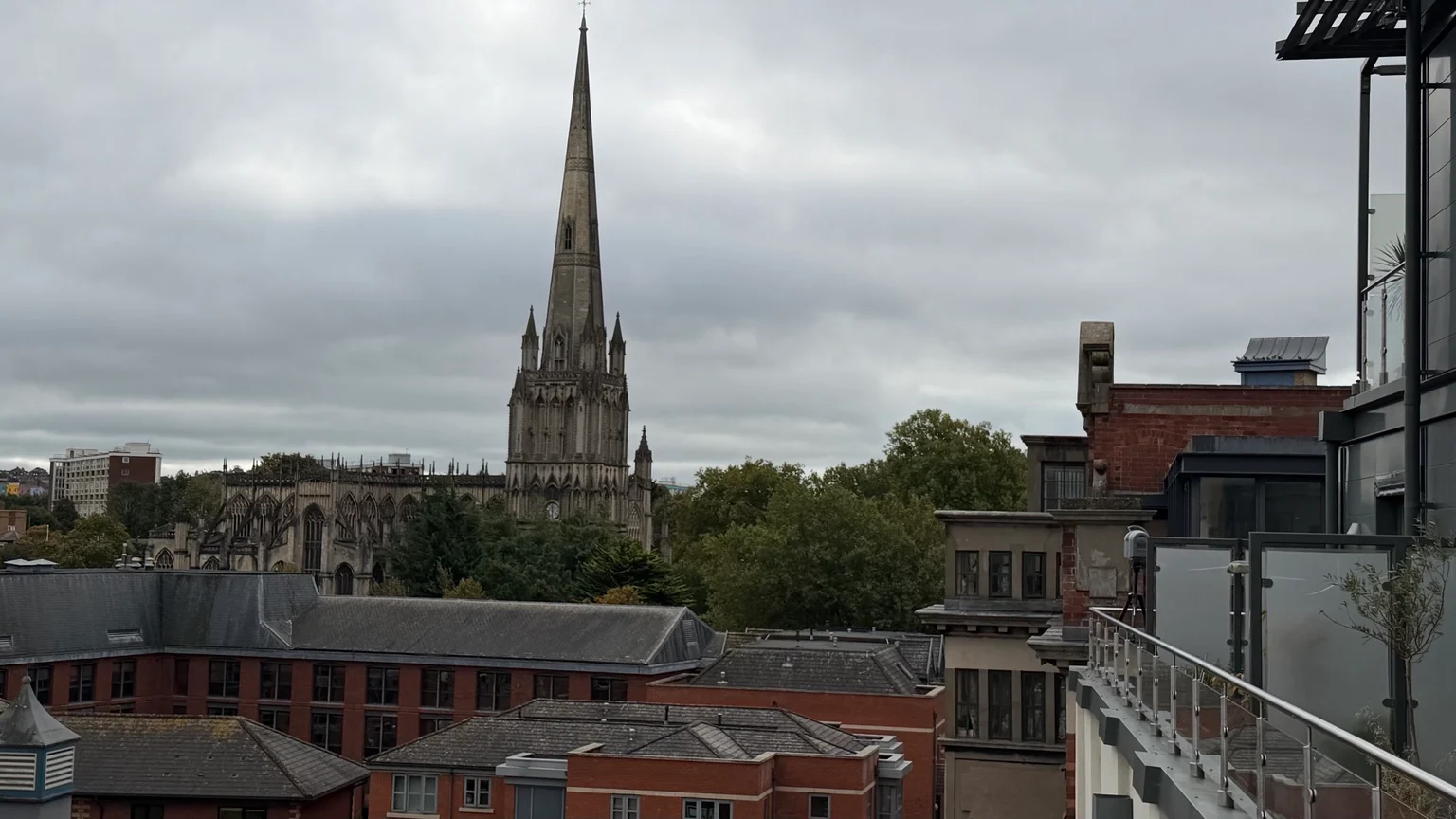 View from the survey balcony across Bristol roofs towards a church spire, with the scanner beside the building on the right.