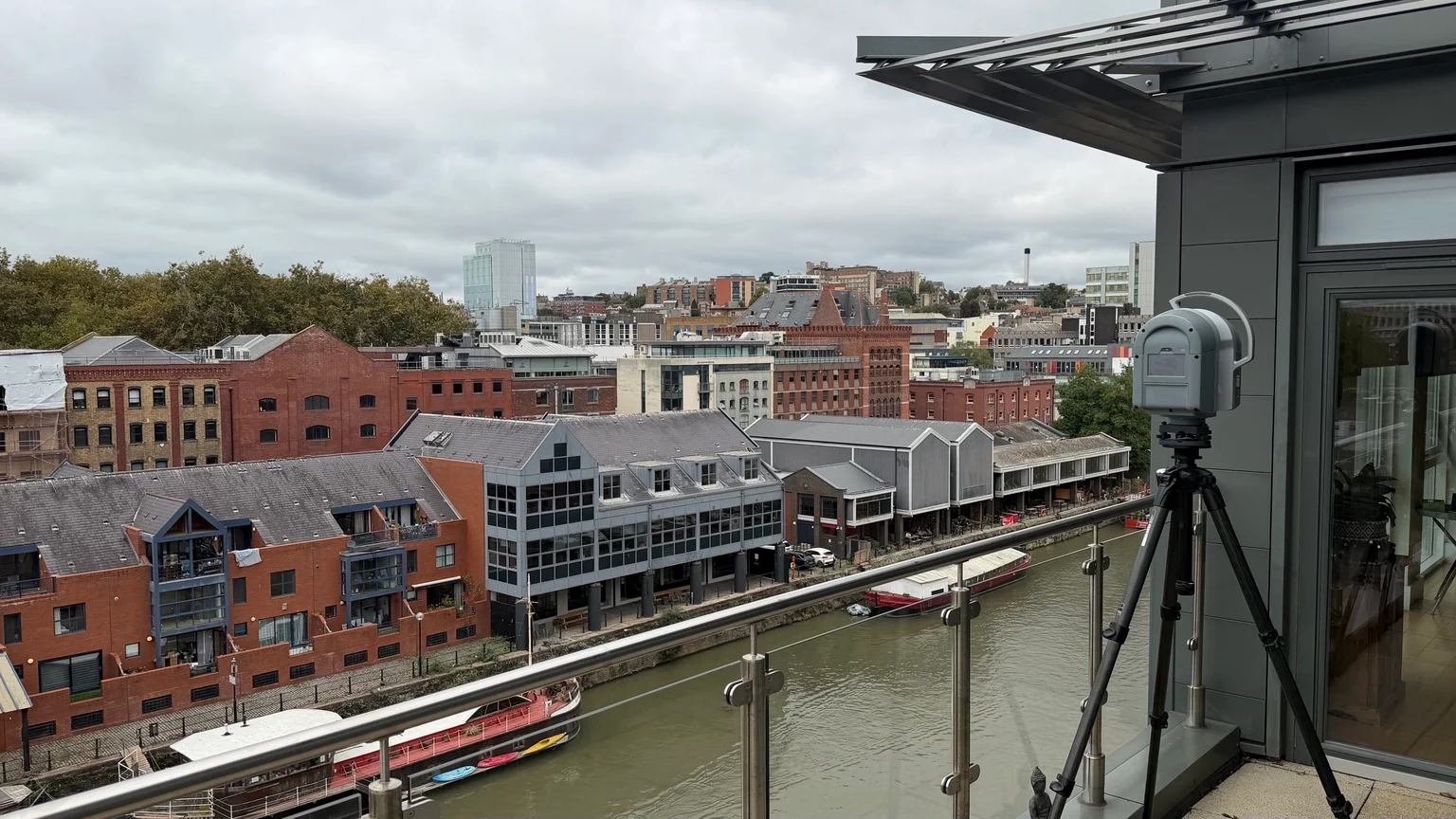 Laser scanner on a high-level balcony overlooking the canal and buildings in Bristol.